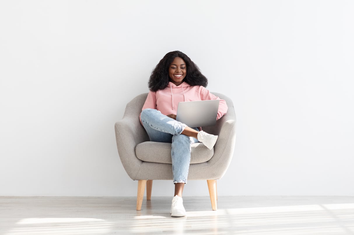 Happy Black Woman Independent Contractor Using Laptop at Home